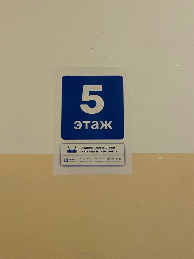 Синяя наклейка «5 этаж» на стене подъезда