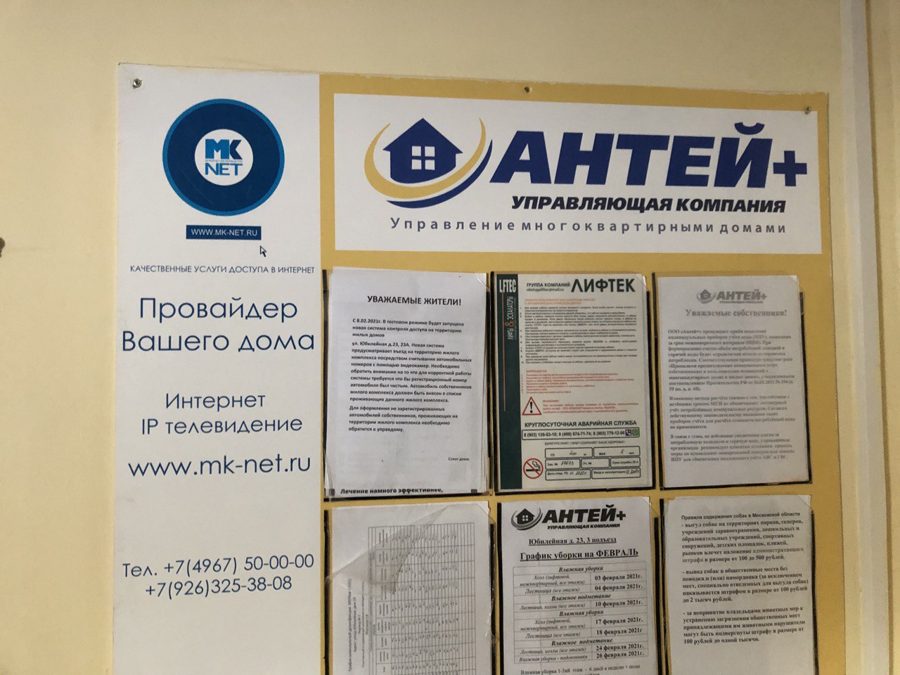 Информационный стенд управляющей компании с шестью кармашками в подъезде